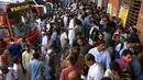 Kerumuman orang menunggu bus yang akan membawa mereka ke tempat tujuannya di sebuah terminal bus di Lahore, Pakistan pada 27 Juni 2023. (Photo by Arif ALI / AFP)