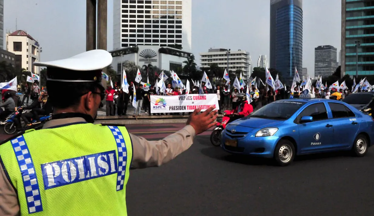 Aparat kepolisian berjaga di sekitar lokasi aksi unjuk rasa ratusan massa KSPI di Bundaran HI Jakarta, (22/7/2014). (Liputan6.com/Johan Tallo)