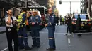 Polisi berjaga di tempat kejadian setelah seorang pria menikam wanita dan berusaha menikam orang lain di pusat kota Sydney (13/8/2019). Dilaporkan satu wanita tewas di salah satu blok lain tetapi tidak jelas kematian wanita tersebut terkait insiden penikaman atau bukan. (AFP Photo/Saeed Khan)