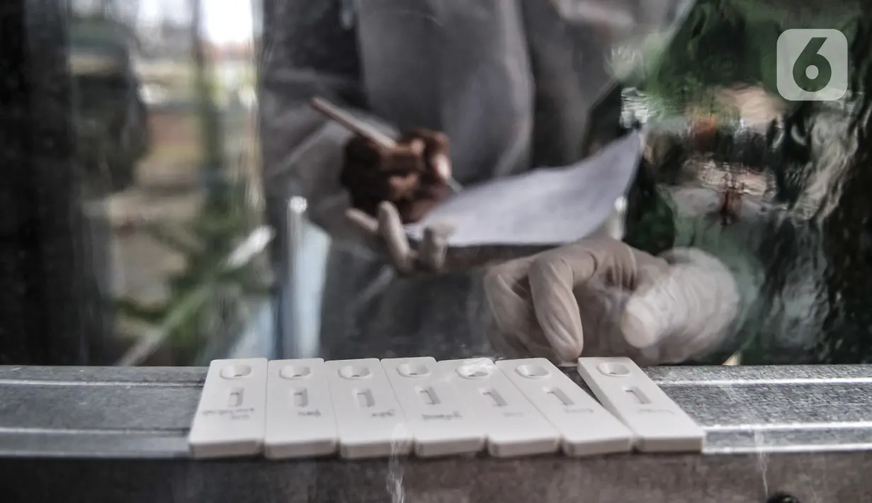Tenaga kesehatan saat mendata hasil tes antigen di Terminal Kampung Rambutan, Jakarta, Minggu (3/1/2021). Pengelola Terminal Kampung Rambutan menyediakan tes antigen bagi penumpang yang baru tiba jika tidak memiliki surat kesehatan dengan harga Rp150 ribu per orang. (merdeka.com/Iqbal S. Nugroho)
