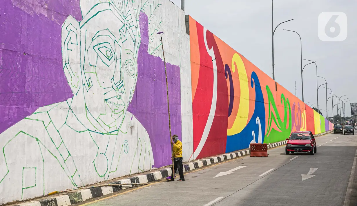 Pekerja menyelesaikan pembuatan mural di Flyover Gaplek, Tangerang Selatan, Rabu (10/3/2021). Konsep muralnya adalah "Tangsel Membangun". (Liputan6.com/Faizal Fanani)