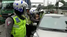 Menghindari razia seorang pengendara mobil nyaris menabrak petugas polisi yang memggelar operasi pajak kendaraan.