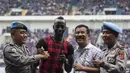 Dua orang polisi mengajak foto bersama manajer Persib Bandung, Umuh Muchtar dan Makan Konate. Kehadiran pemain yang membawa Persib juara ISL 2014 itu tentu memberikan kegembiraan bagi Bobotoh. (Bola.com/Vitalis Yogi Trisna)