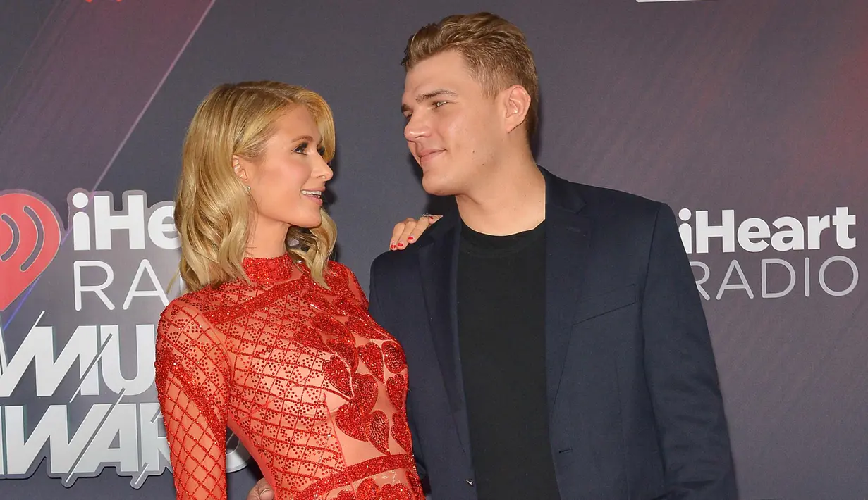 Paris Hilton dan tunangannya Chris Zylka saling bertatapan saat menghadiri iHeartRadio Music Awards 2018 di Inglewood, California, AS (11/3). (AFP Photo/Rachel Murray)