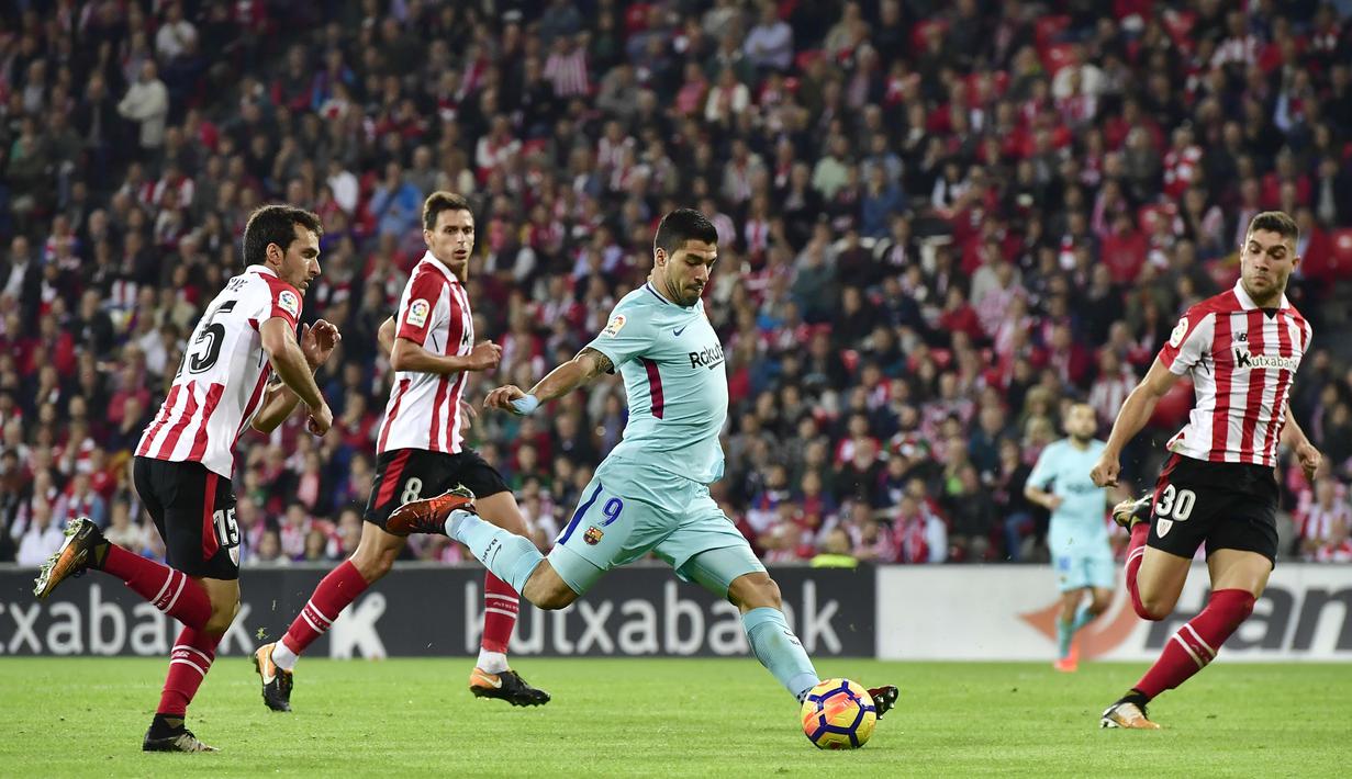 Aksi pemain FC Barcelona, Luis Suarez melakukan tembakan setelah melewati adangan para pemain Athletic Bilbao  pada lanjutan La Liga Santander di San Mames stadium, Bilbao, (28/102017). Barcelona menang 2-0. (AP/Alvaro Barrientos)