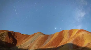 Foto eksposur panjang yang diabadikan pada 13 Agustus 2020 ini menunjukkan hujan meteor Perseid di Taman Geologi Nasional Danxia Zhangye di Zhangye, Provinsi Gansu, China barat laut. (Xinhua/Zhong Xiaoliang)