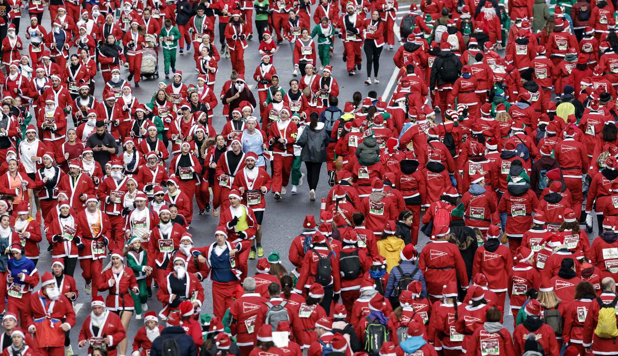 Berbeda dengan lomba lari biasa, dalam ajang tahunan ini para peserta beraksi di lintasan dengan mengenakan kostum Santa Claus yang didominasi warna merah, lengkap dengan janggut putih dan topi. Tampak dalam foto, ribuan pelari yang mengenakan kostum Santa Claus berpartisipasi dalam edisi ke-14 lomba Santa Claus, sebuah lari santai sejauh 4,5 km melalui jalan-jalan Madrid pada Minggu 21 Desember 2025. (OSCAR DEL POZO/AFP)