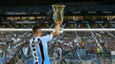 Pemain Gremio, Luis Suarez mengangkat trofi setelah memenangkan Gaucho Championship di Arena do Gremio Stadium, Porto Alegre, Brasil, 8 April 2023. (AFP/Silvio Avila)