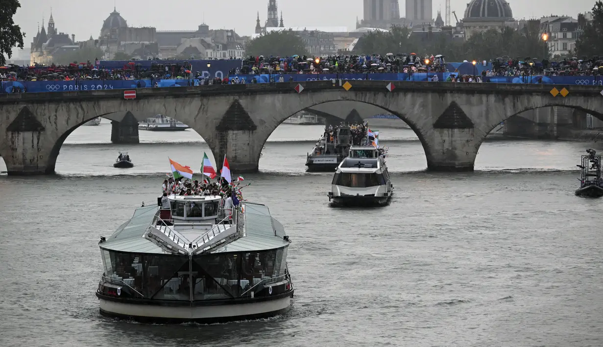 Kontingen Indonesia bersama kontingen India dan Iran berlayar di atas perahu saat upacara pembukaan Olimpiade Paris 2024 di Sungai Seine, Paris Prancis, 26 Juli 2024. (AFP/Sebastien Bozon)