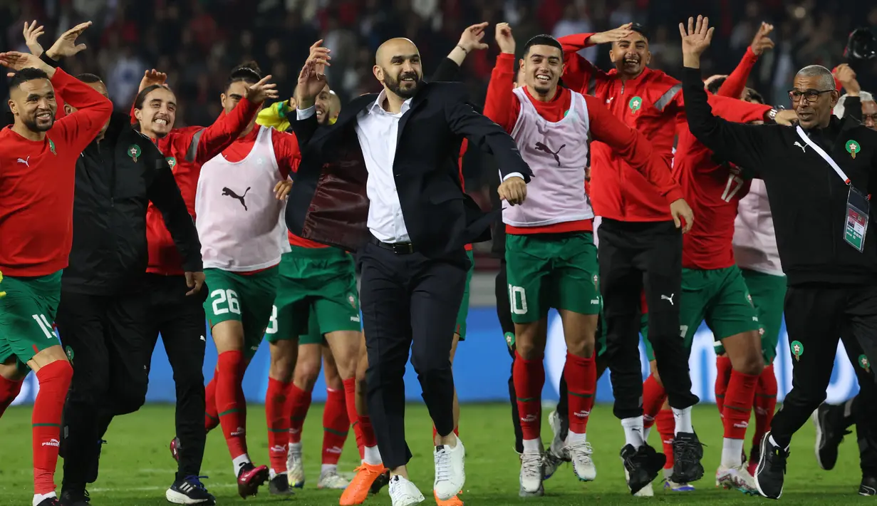 Pelatih Maroko Walid Reragui (Tengah) dan para pemainnya menyapa para suporter setelah laga uji coba internasional melawan Brasil di Grand Stade de Tanger, Tangier, Minggu (26/3/2023) pagi WIB. Timnas Maroko kembali membuat kejutan dengan membungkam Brasil 2-1. (Photo by Fadel Senna / AFP)