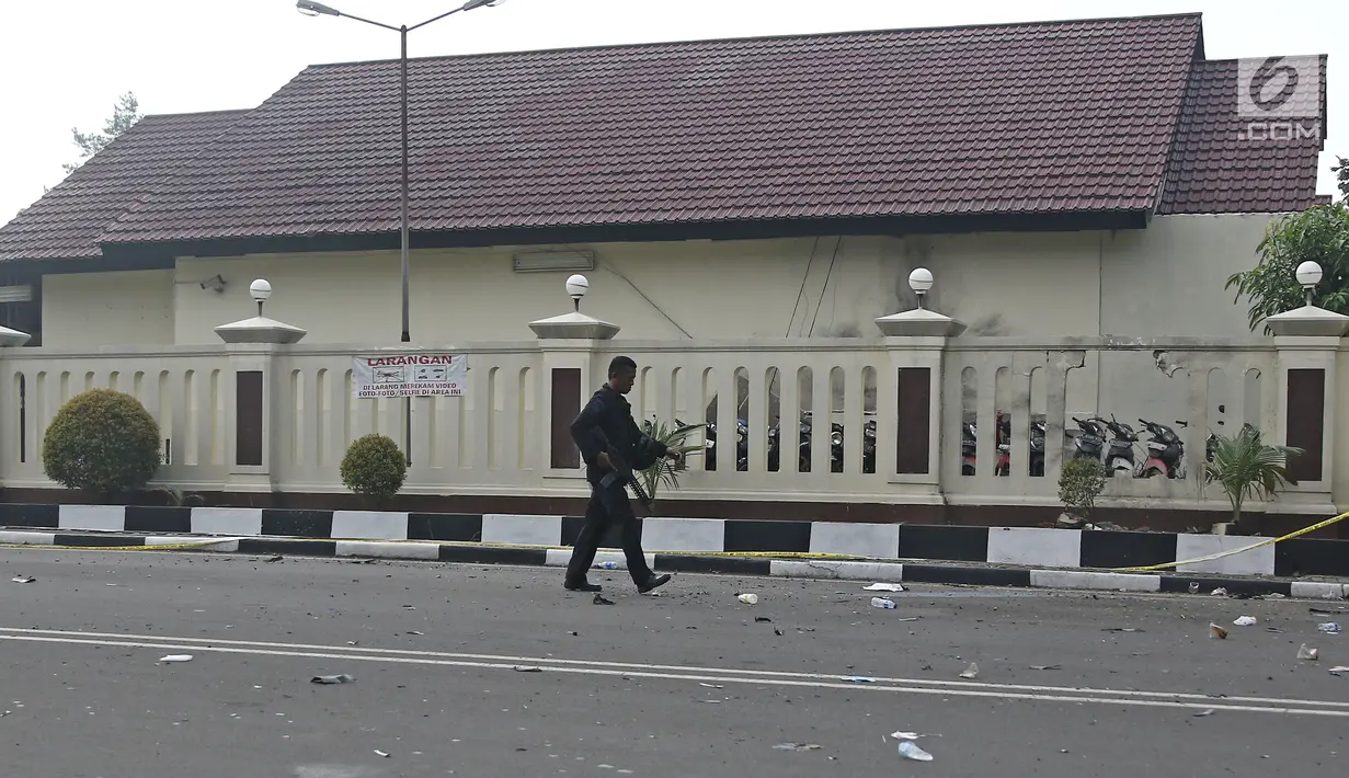 Aparat polisi bersenjata lengkap berjalan di depan Rutan Cabang Salemba Mako Brimob seusai operasi penanggulangan di Depok, Kamis (10/5). Setelah sekitar 34 jam, para napi terorisme yang membuat kerusuhan akhirnya menyerah. (Liputan6.com/Herman Zakharia)