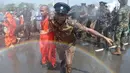 Seorang polisi mengamankan biksu saat aksi protes di kota pelabuhan selatan Hambantota, Sri Lanka (7/1). Mereka memprotes pembuatan zona industri untuk investasi China di sebuah kawasan di Sri Lanka. (AFP/ Ishara S. Kodikara)