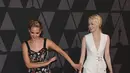 Aktris Jennifer Lawrence saat bercanda dengan Emma Stone di karpet merah saat menghadiri acara Governors Awards ke-9 di Los Angeles, California, AS (11/11). (Kevin Winter/Getty Images/AFP)