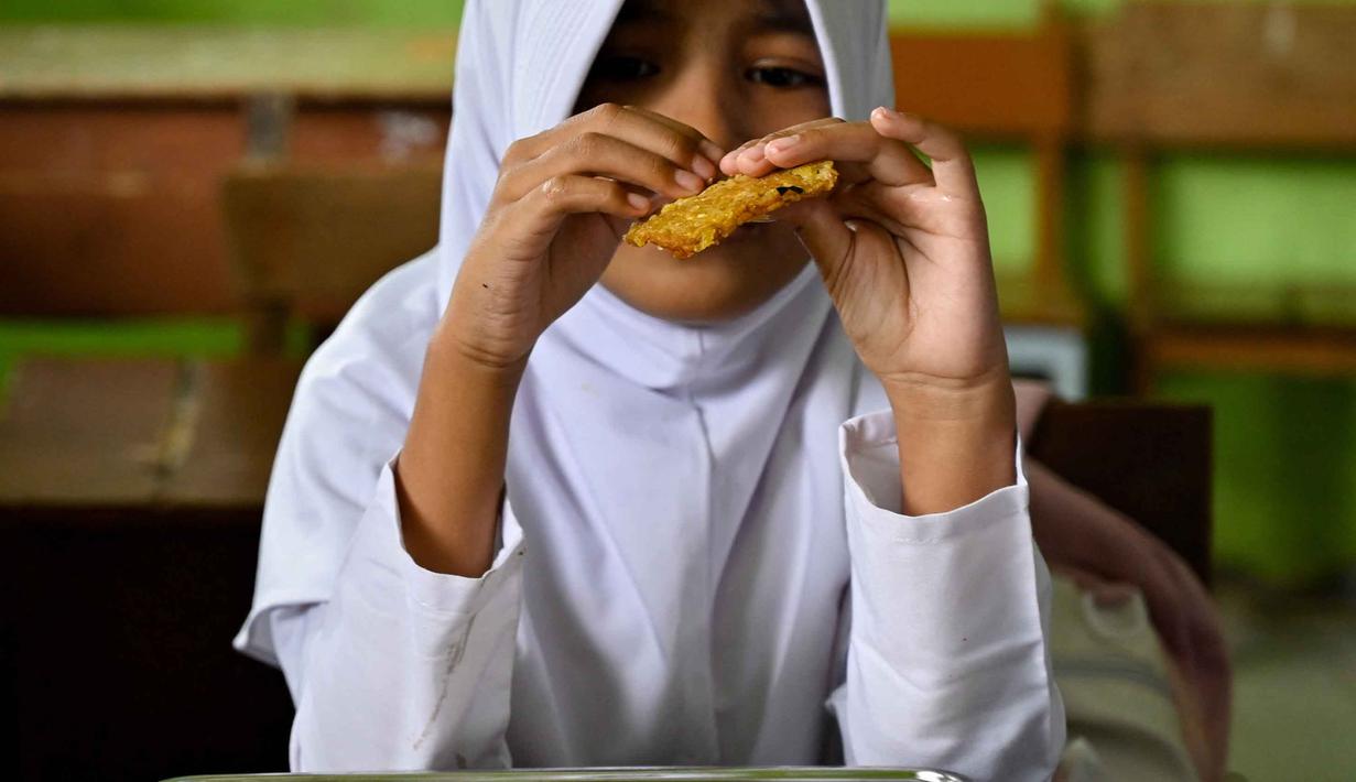 Diketahui, program Makan Bergizi Gratis (MBG) bertujuan membantu orang tua wali memenuhi kebutuhan gizi anak didik. Serta dapat meringankan beban perekonomian orang tua atau wali murid. (CHAIDEER MAHYUDDIN/AFP)