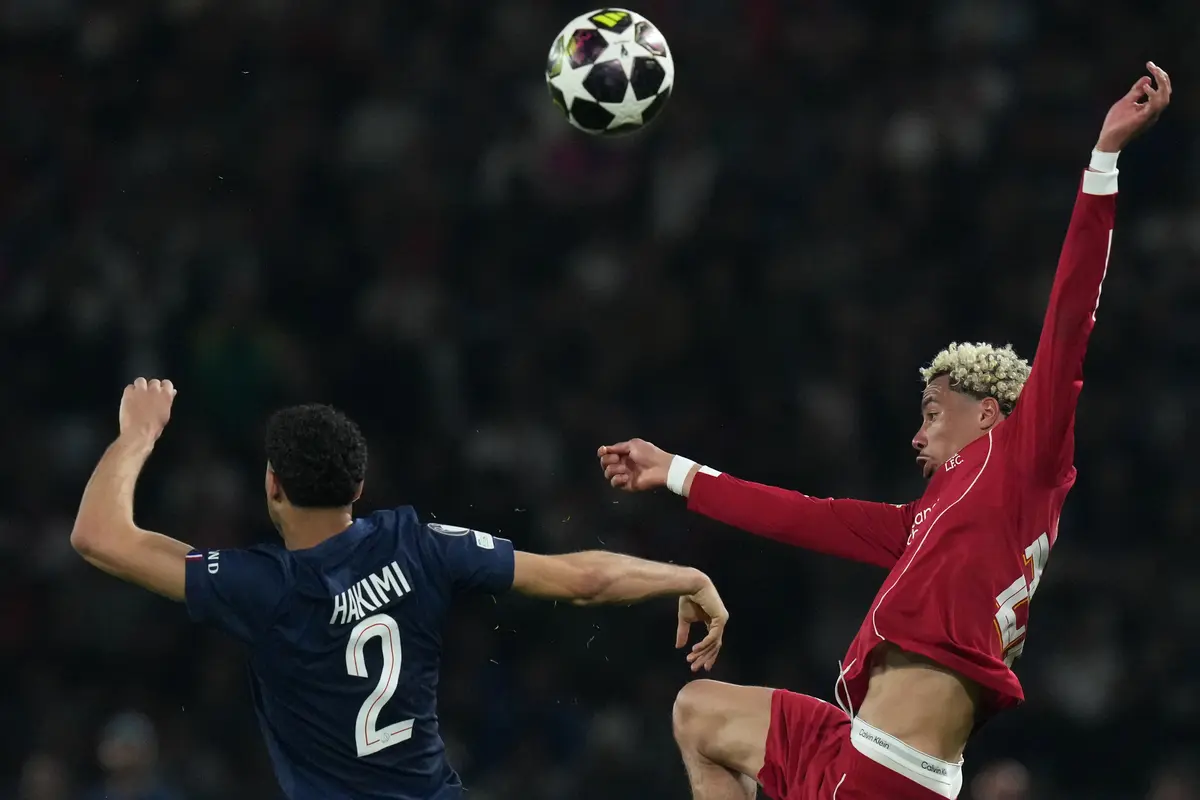 Pemain PSG Achraf Hakimi (kiri) dan pemain Liverpool Hugo Ekitike berebut bola