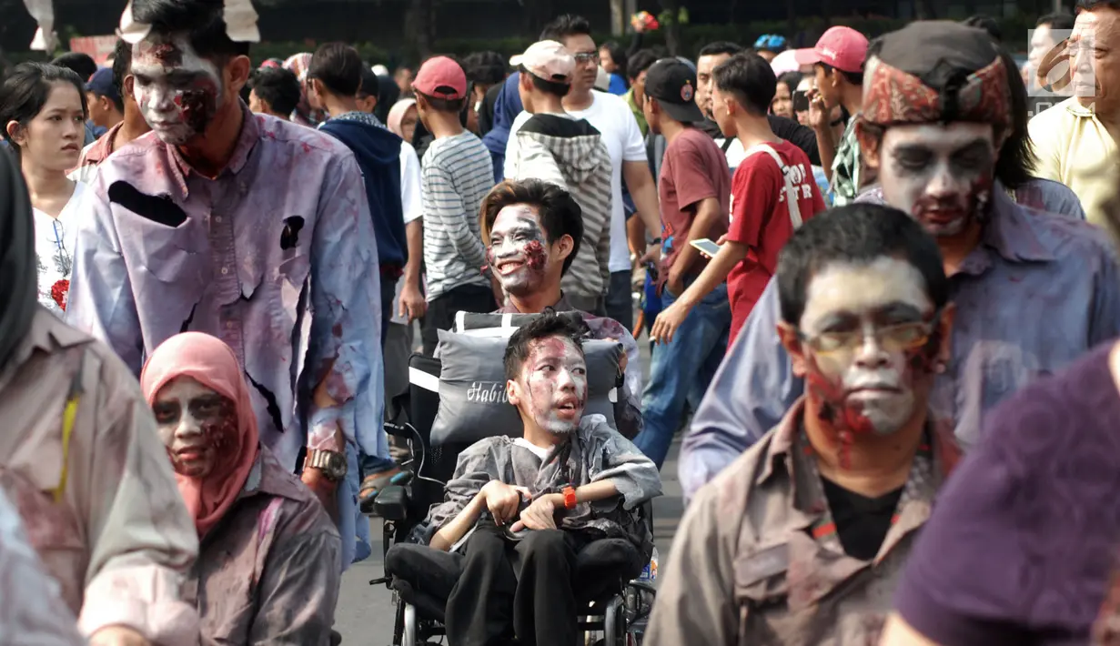 Sejumlah penyandang disabilitas berkursi roda menggunakan kostum zombie saat melakukan aksi teatrikal dalam Festival Bebas Batas 2018 di CFD Jakarta, Minggu (14/10). (Merdeka.com/Iqbal Nugroho)