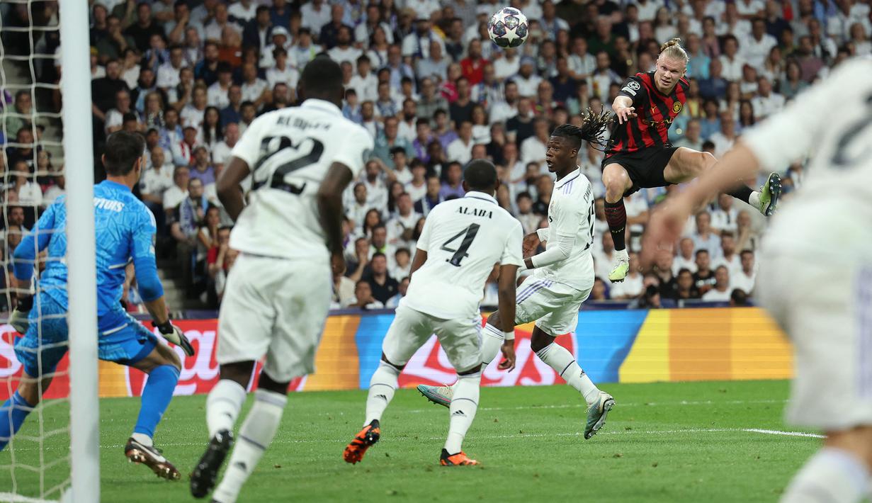 Pemain Manchester City, Erling Haaland (kanan) berusaha mencetak gol dibayangi pemain Real Madrid, Eduardo Camavinga pada laga leg pertama semifinal Liga Champions 2022/2023 di Santiago Bernabeu, Madrid, Rabu (10/05/2023) WIB. Laga berakhir dengan skor 1-1. (AFP/Oscar Del Pozo)