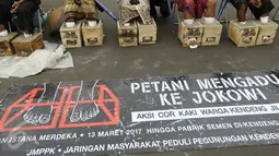 Sebuah spanduk besar yang didampang saat sejumlah Petani Kendeng, Pati menggelar aksinya di depan Istana Negara, Jakarta, Selasa (14 /3). (Liputan6.com/Helmi Afandi)