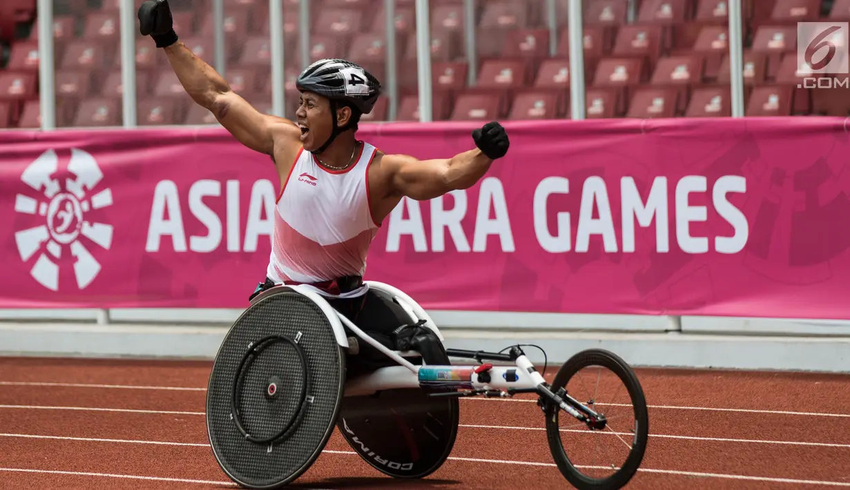 Pebalap kursi roda Indonesia, Jaenal Aripin, melakukan selebrasi usai meraih medali perak pada Asian Para Games cabang atletik nomor balap kursi roda 200 meter T 54 di SUGBK, Jakarta, Jumat (12/10). (Bola.com/Vitalis Yogi Trisna)