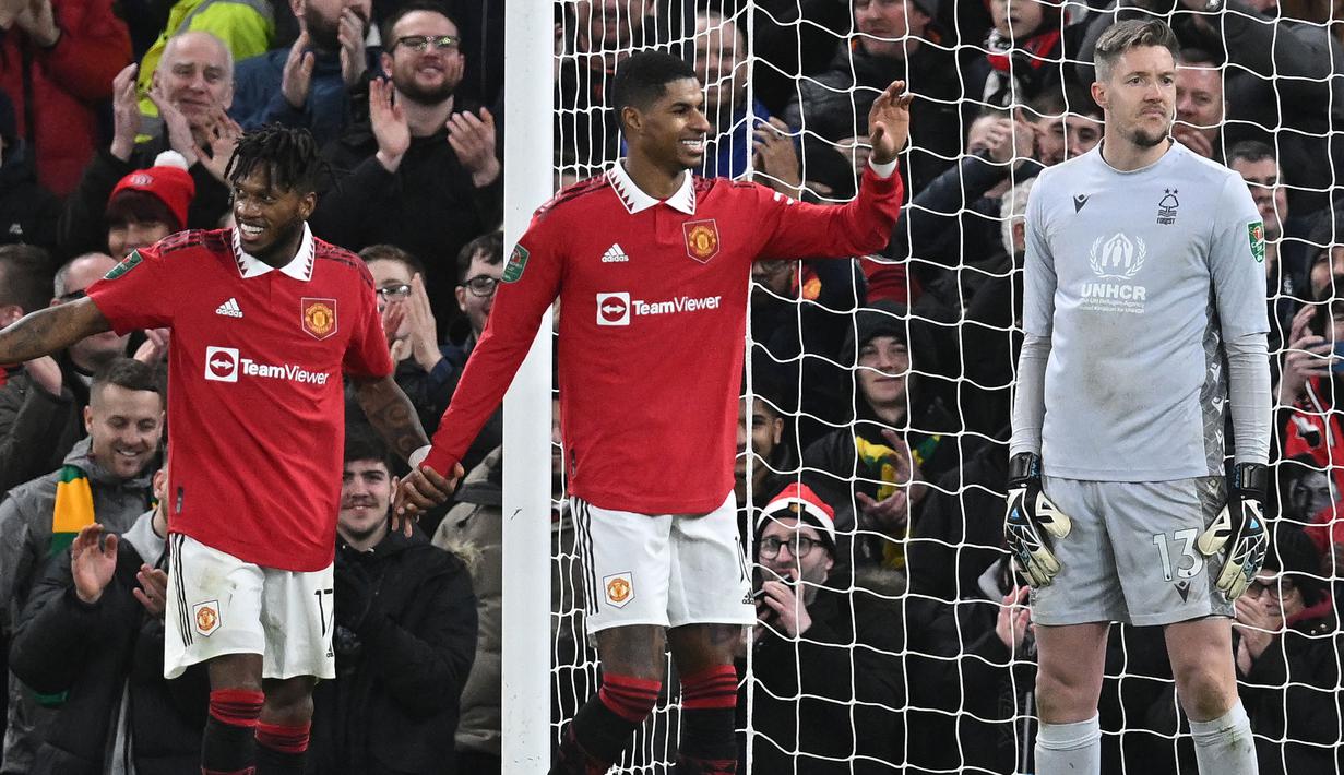 Pemain Manchester United, Marcus Rashford melakukan selebrasi setelah atas gol yang dicetak oleh Fred pada laga leg kedua Semifinal Carabao Cup 2022/2023 melawan Nottingham Forest di Old Trafford, Manchester, Kamis (02/02/2023) WIB. Rashford berhasil membuat dua assist untuk kemenangan 2-0 MU. (AFP/Paul Ellis)
