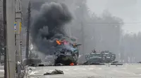 Foto mobil pengangkut personel tentara Rusia terbakar di Kharkiv, Ukraina, yang diambil pada 27 Februari 2022. (dok. Sergey BOBOK/ AFP)