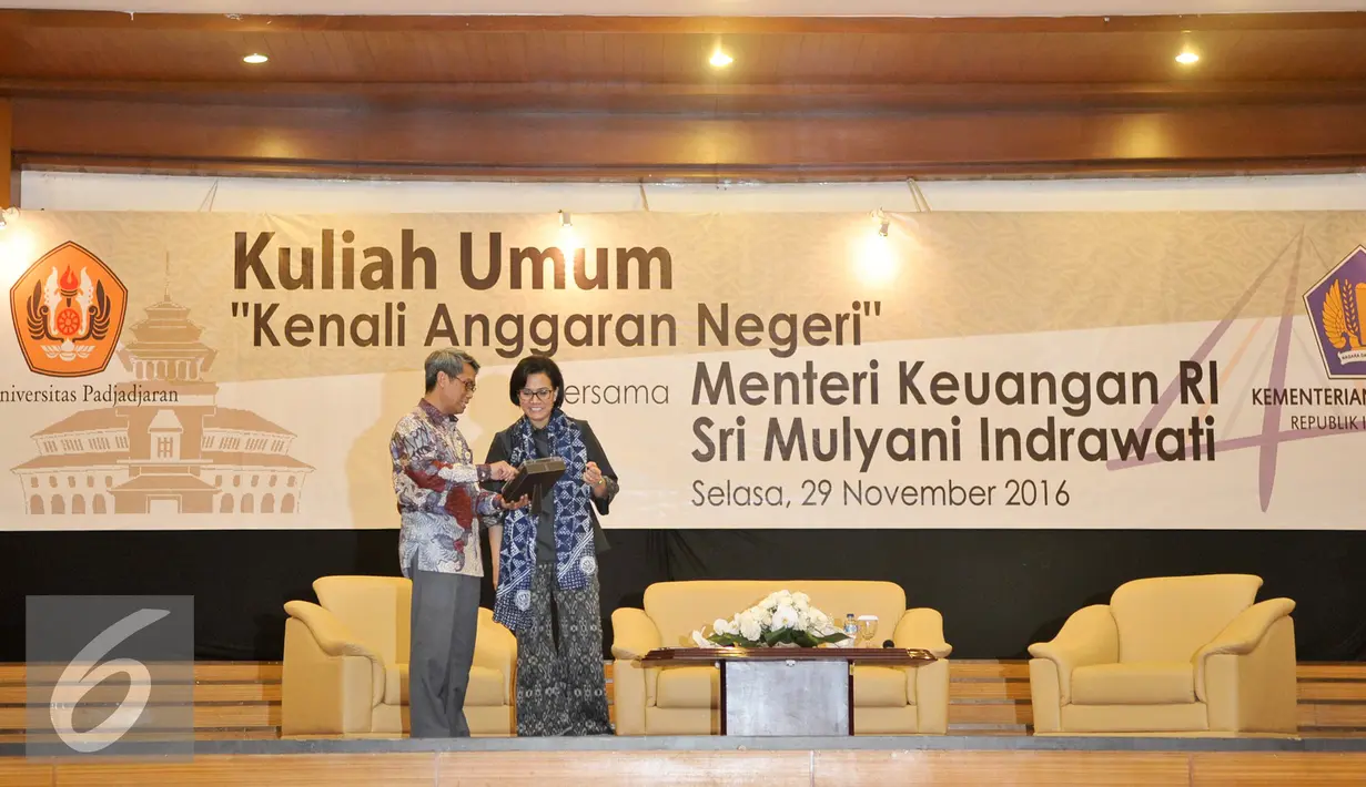 Rektor Unpad, Tri Hanggono Achmad meberikan kenang-kenangan kepada Menteri Keuangan Sri Mulyani Indrawati seusai kuliah umum di Graha Sanusi Unpad, Kota Bandung, Selasa (29/11). (Liputan6.com/Yoppy Renato)