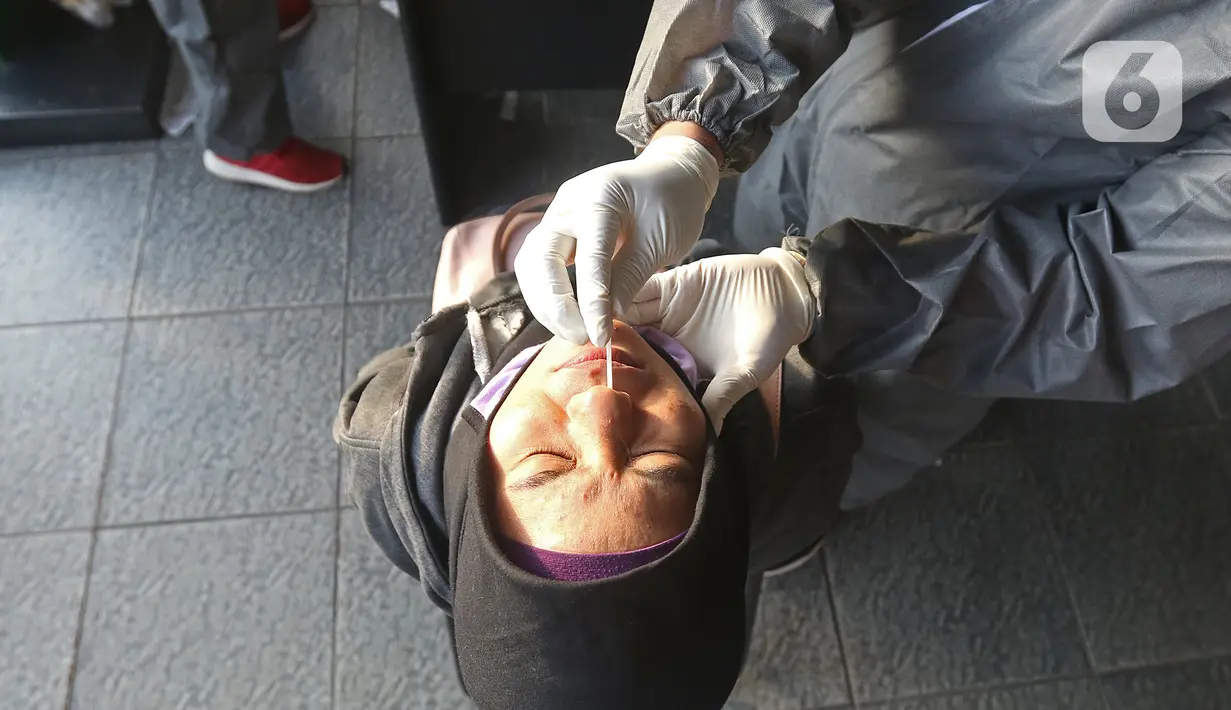 Petugas medis mengambil sampel penumpang KRL Commuter Line saat tes swab dengan metode polymerase chain reaction (PCR) di Stasiun Bekasi, Selasa, (5/5/2020). Pemkot Bekasi melakukan tes swab secara massal setelah tiga penumpang KRL dari Bogor terdeteksi virus corona. (Liputan6.com/Herman Zakharia)