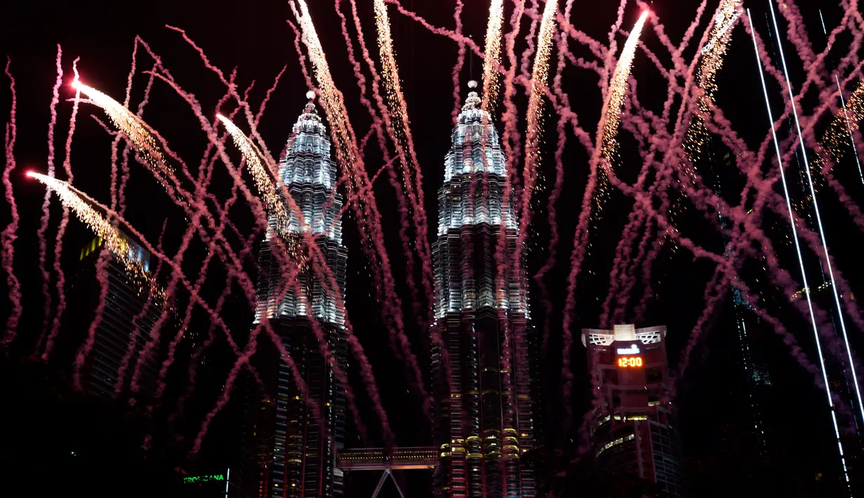 Kembang api menghiasi Menara Kembar Petronas saat perayaan malam Tahun Baru 2019 di Kuala Lumpur, Malaysia, Selasa (1/1). (AP Photo/Yam G-Jun)