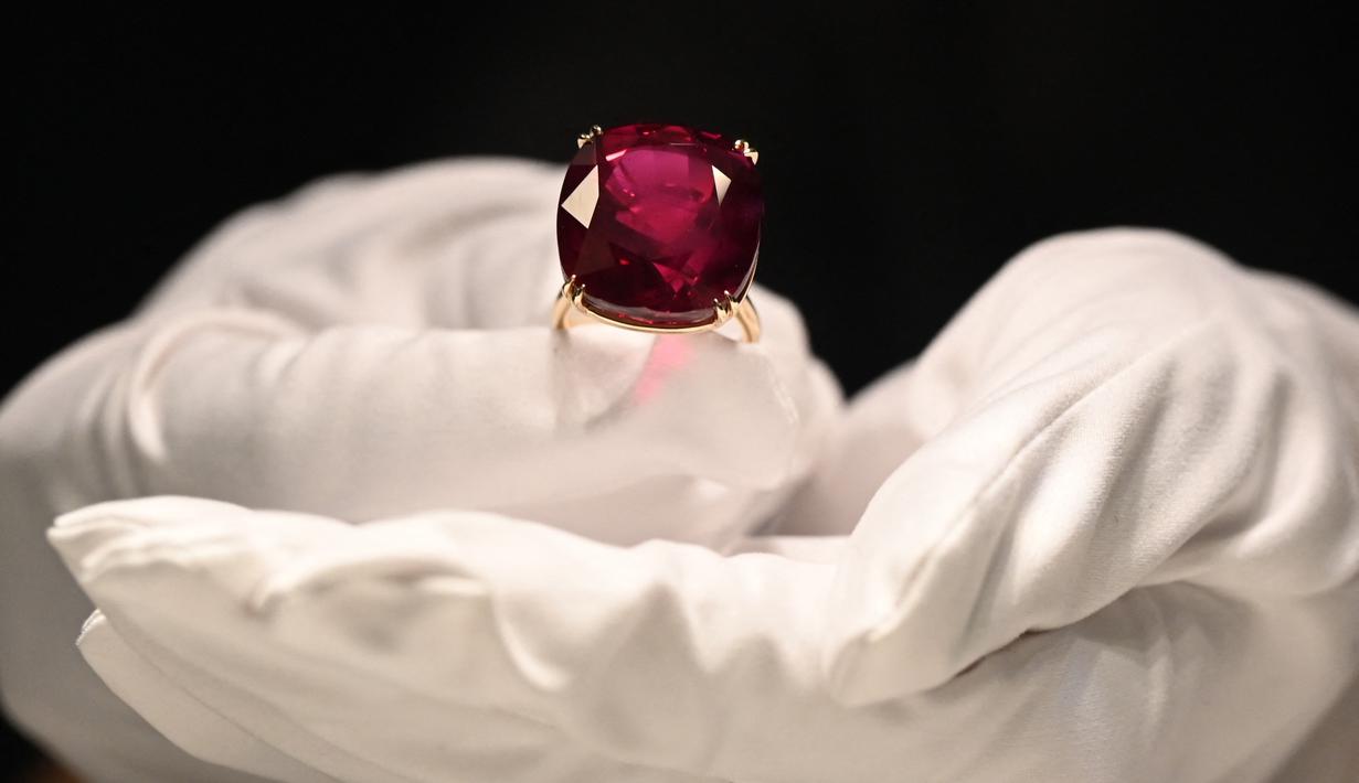 Perwakilan dari Sotheby's mengangkat Estrela de Fura Ruby, batu rubi terbesar di dunia, di Hong Kong pada 17 April 2023. (Photo by Peter PARKS / AFP)
