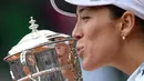 Garbine Muguruza mencium trofi usai mengalahkan Serena Williams 7-5, 6-4 pada final Roland Garros 2016 Prancis Terbuka di Paris (4/6/2016). (AFP/Miguel Medina)
