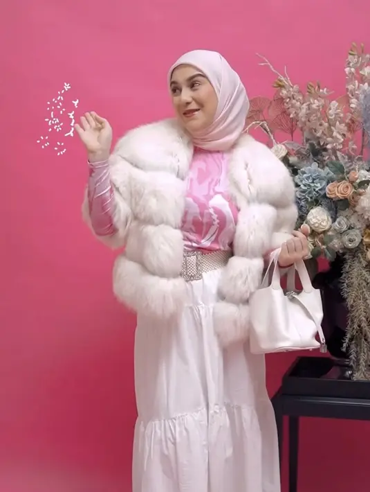 Irish juga tampil mengenakan long sleeve pink yang serasi dengan kerudungnya. Ia memadukannya dengan jaket berbulu putih serasi dengan rok ruffle, hand bag, dan stiletto heels nya. @_irishbella_
