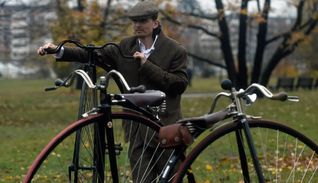 Seorang penggemar sepeda mengenakan kostum sejarah sambil menuntun Penny Farthing atau dikenal sebagai sepeda roda tinggi selama kompetisi tradisonal 'One Mile Race' di Praha, Republik Ceko pada 3 November 2018. (Photo by Michal CIZEK / AFP)