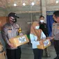 Polisi dan wartawan berikan bantuan untuk anak nakes yang meninggal karena Covid-19. (Foto: Liputan6.com/Felek Wahyu)