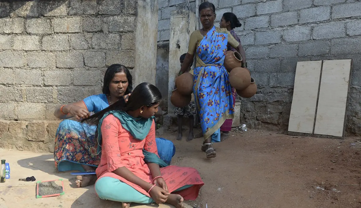 Seorang wanita membawa pot tanah untuk dikeringkan di luar rumahnya jelang Festival Diwali di pinggiran Hyderabad, India, 26 Oktober 2021. Diwali adalah salah satu festival besar yang dirayakan oleh umat Hindu, Jain, Sikh dan beberapa umat Buddha, terutama umat Buddha Newar. (NOAH SEELAM/AFP)