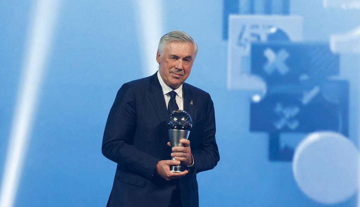 Pelatih Real Madrid, Carlo Ancelotti memegang trofi penghargaan pelatih terbaik FIFA 2024 dalam acara FIFA Awards 2024 yang berlangsung di Doha, Qatar, Selasa (18/12/2024) waktu setempat. (AFP/Karim Jaafar)