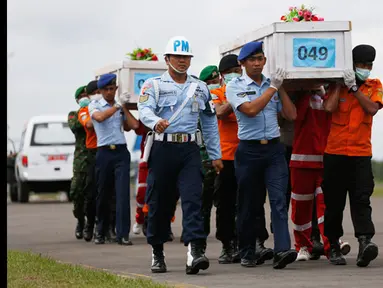 Tim SAR gabungan membawa dua peti mati jenazah penumpang pesawat AirAsia QZ8501 yang jatuh pada tanggal 28 Desember 2014  di pangkalan udara Iskandar, Pangkalan Bun, Kalteng, (19/1/2015). (REUTERS / Beawiharta)