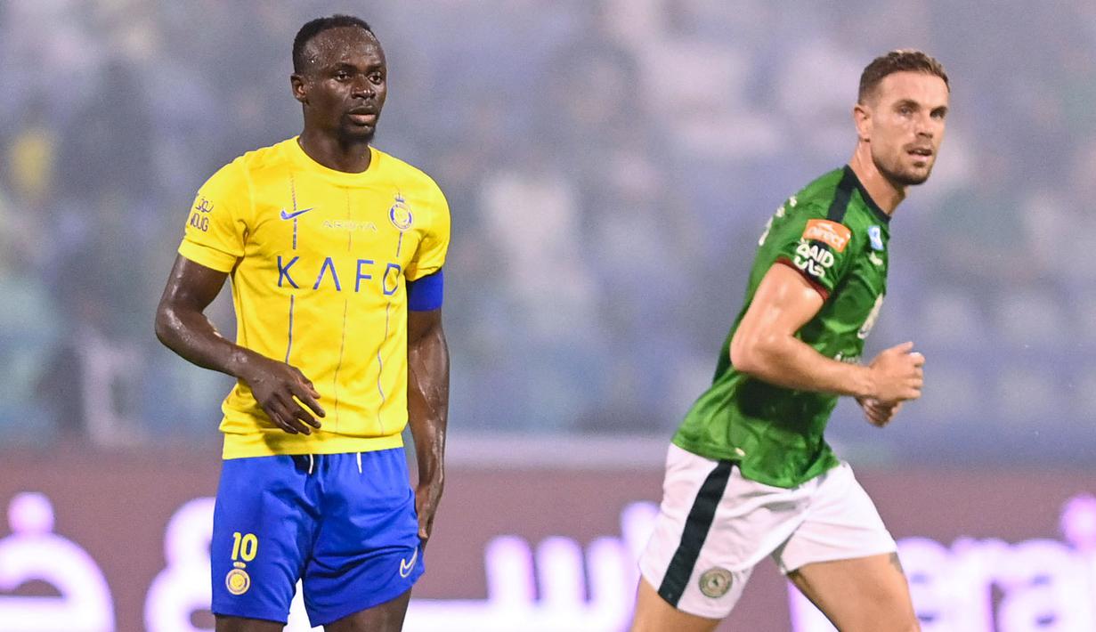 Pemain Al-Nassr, Sadio Mane (kiri) dan pemain Al-Ettifaq, Jordan Henderson saat laga pekan pertama Liga Arab Saudi 2023/2024 di Prince Mohamed bin Fahd Stadium, Dammam, Selasa (15/08/2023) dini hari WIB. (AFP/Ali Alhaji)