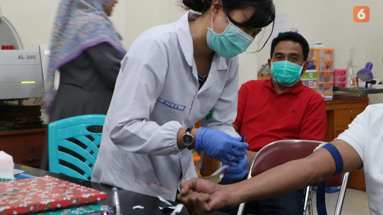 Petugas kesehatan mengambil sampel darah warga