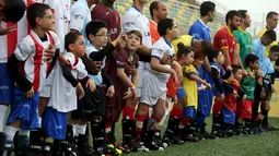 Anak berkebutuhan khusus dan pesepakbola Brasil bersiap bermain bola saat acara "World Boots" di Neymar Institute, Brasil, 7 Juni 2015. Acara tersebut diadakan pesepakbola Brasil Neymar untuk anak-anak berkebutuhan khusus. (REUTERS/Paulo Whitaker)