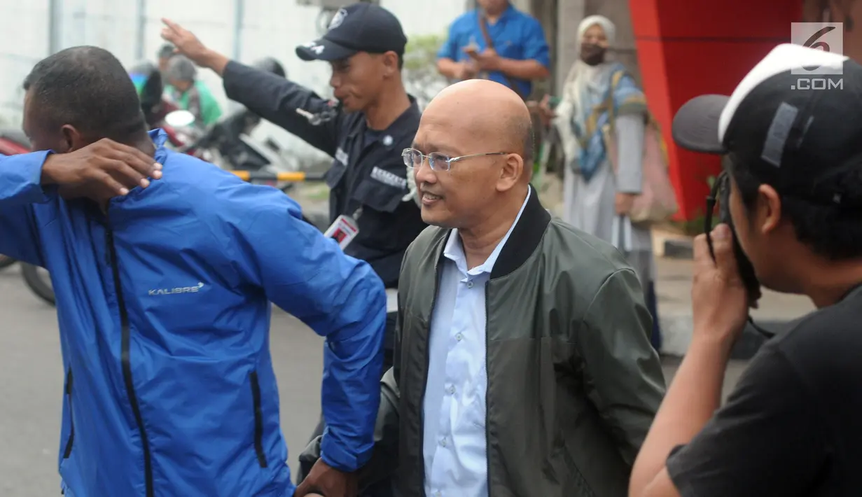Direktur PT Humpuss Transportasi Kimia (HTK), Taufik Agus didampingi pengawal menghindari wartawan usai menjalani pemeriksaan penyidik KPK, Jakarta, Selasa (9/4). Taufik diperiksa terkait dugaan menerima suap kerjasama pengakutan dibidang pelayaran penggakutan Pupuk.(merdeka.com/Dwi Narwoko)