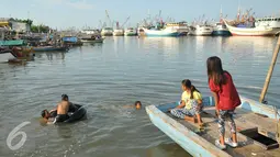 Sejumlah anak berenang di laut di kawasan Luar Batang, Penjaringan, Jakarta, Senin (28/3). Pemprov DKI Jakarta menargetkan pembangunan 300 Ruang Publik Terpadu Ramah Anak (RPTRA) di seluruh kawasan Jakarta. (Liputan6.com/Gempur M Surya) 