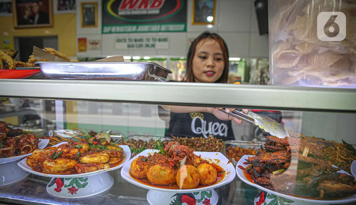 Pekerja melayani pengunjung di rumah makan Warteg Bahari, Jakarta, Rabu (1/12/2021). Dalam salinan Inmendagri tersebut juga tertulis waktu makan maksimal selama 60 menit. (Liputan6.com/Faizal Fanani)