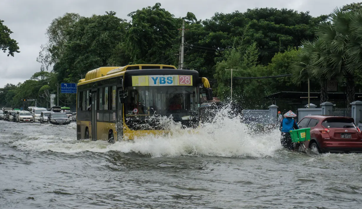 Sebuah bus melewati jalan yang banjir di pinggiran Yangon (17/8/2022). Banjir telah melanda banyak bagian negara bagian termasuk Zeya Myine, Thiri Myine, Thiri Minglar, Myain Thayar, Shwe Pyae Aye, Zeya Thiri, dan Phaekhin Wards. (AFP/Stringer)