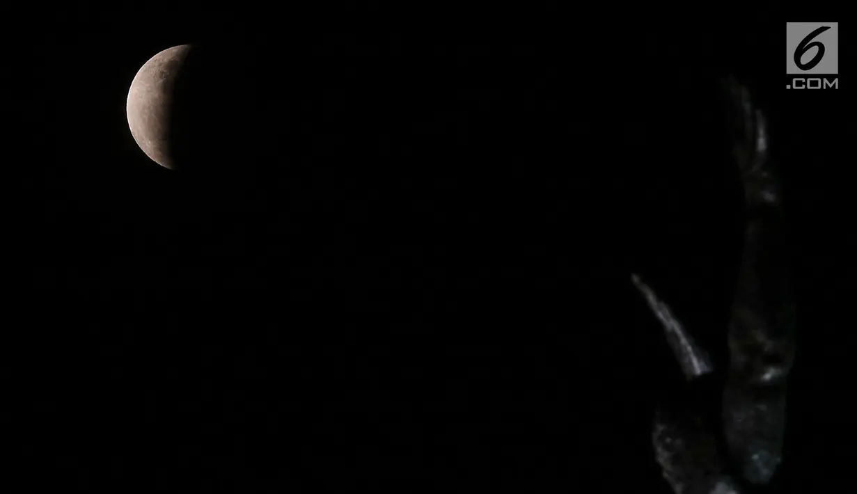 Fenomena gerhana bulan sebagian (parsial) terlihat di langit Jakarta pada Rabu (17/7/2019) dini hari. Gerhana bulan terakhir dalam tahun 2019 ini merupakan fenomena jenis gerhana bulan parsial, karena masih ada yang tampak sebagian. (Liputan6.com/Johan Tallo)