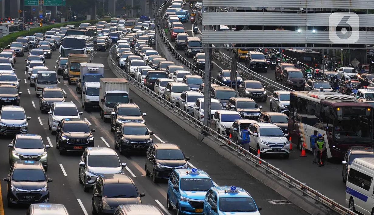 Transaksi yang dibantu oleh petugas tersebut dilakukan untuk mengurai antrean kemacetan kendaraan yang masuk ke tol pada jam sibuk pulang kerja. (merdeka.com/Imam Buhori)