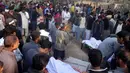 Sejumlah orang berkumpul di pemakaman korban tewas minuman keras oploson di Toba Tek Singh sekitar 338 km dari Islamabad, Selasa (27/12). Selain memakan korban jiwa, minuman oplosan rumahan itu juga membuat puluhan orang dilarikan ke rumah sakit (STR/AFP)