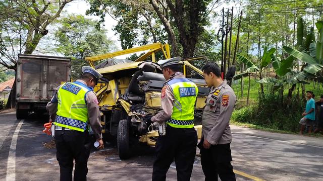 Para petugas Satlantas Polres Garut, tengah melakukan olah TKP kecelakaan dua kendaraan pengangkut barang di jalur mudik nasional Limbangan, Garut. (Liputan6.com/Jayadi Supriadin)