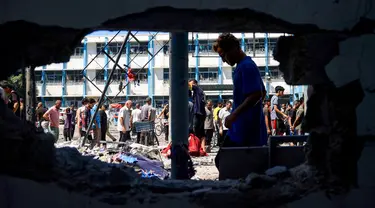 Warga Palestina memeriksa kerusakan di Sekolah Al-Razi yang dikelola organisasi Persatuan Bangsa Bangsa (PBB) di kamp pengungsi Nuseirat setelah serangan Israel pada 16 Juli 2024. (Eyad BABA/AFP)