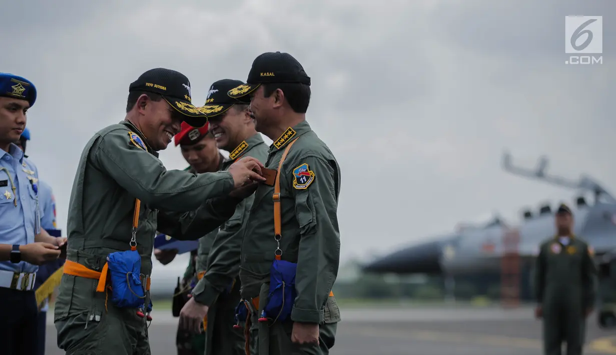 KSAU Marsekal TNI Yuyu Sutisna (kiri) menyematkan Wing Penerbang Kehormatan kepada KSAL Laksamana TNI Siwi Sukma Adji sebelum joy flight di Lanud Halim Perdanakusuma, Jakarta, Jumat (5/4). Penyematan tersebut menunjukkan kerja sama dan komitmen AU terhadap soliditas TNI. (Liputan6.com/Faizal Fanani)