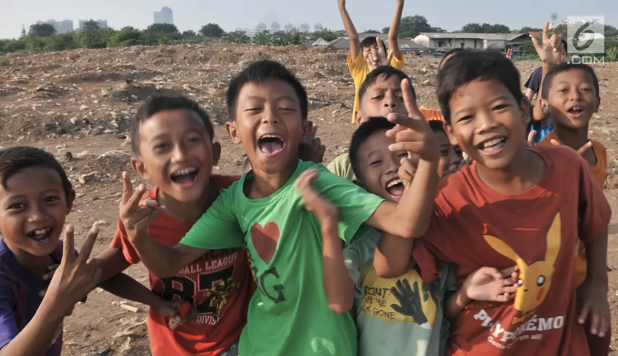 Keceriaan anak-anak saat bermain di lahan sengketa di kawasan Pedongkelan, Jakarta, Kamis (11/7/2019). Meski bertempat tinggal di atas lahan sengketa, anak-anak setempat memanfaatkan tanah kosong yang penuh semak belukar tersebut sebagai sarana bermain ketika sore hari. (merdeka.com/Iqbal S. Nugroho